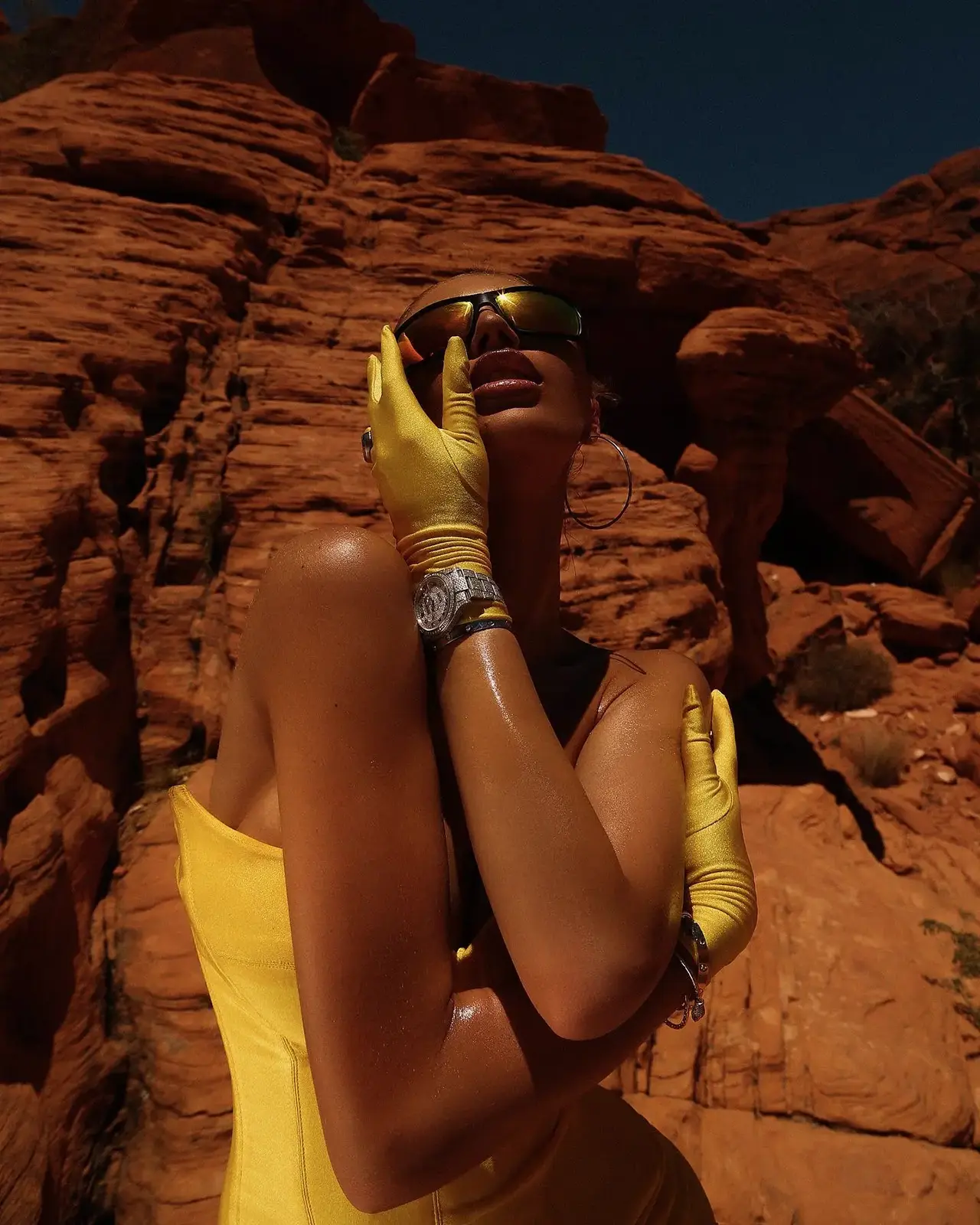 Larger close portrait with yellow gloves against red rocks.